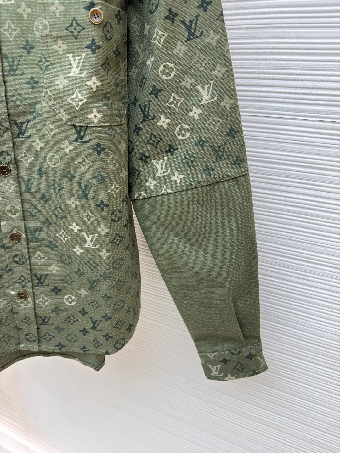 LOUIS VUITTON work jacket-style shirt with full lapel print ●Original version: Purchased and developed for 16,000 ●Item number: 1681953-B50 ●Fabric: denim fabric ●Technology: Printing ●Color: green ●Version: fitted version ●Weight: about 770 grams ●Size: S-M-L-XL ●Description: This LV lapel all-printed work jacket-style shirt adopts positioning cutting technology: before cutting the fabric pieces, the position of the all-printed Monogram pattern is locked through digital typesetting to ensure that the pattern is continuous and without misalignment after splicing, and the pattern alignment error between the body and the solid color splicing area is controlled within 0.5cm. The printing process uses digital direct injection technology: the pigment penetrates the fabric fibers with micron-sized particles, presenting a low-saturation vintage tone while maintaining the breathability of the fabric. The wear resistance of the printing layer reaches level 5 (friction test ≥ 200 times without falling off). The body is made of twill canvas blended fabric, and the splicing parts are reinforced with double-needle buried clip technology. The buttons are made of brass-plated matte paint, and the stitching is made of high-tenacity nylon thread with a tensile strength of 150N. The overall process takes into account both visual integrity and practical durability. The overall wiring is straight and delicate, the fabric is comfortable and soft, and the color is consistent without color difference. It can be matched with the same style to create a fashionable look and control various occasions. Customized accessories, complete with three standards, same style for men and women!